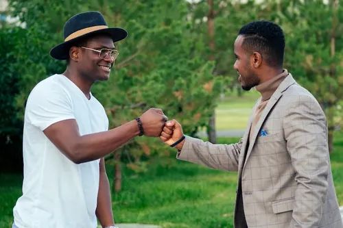 Two men greeting each other with a fist bump outdoors