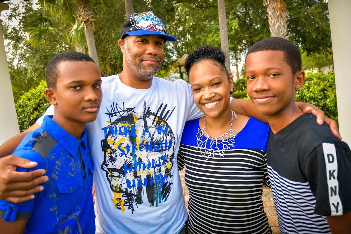 A family of four smiling together outdoors