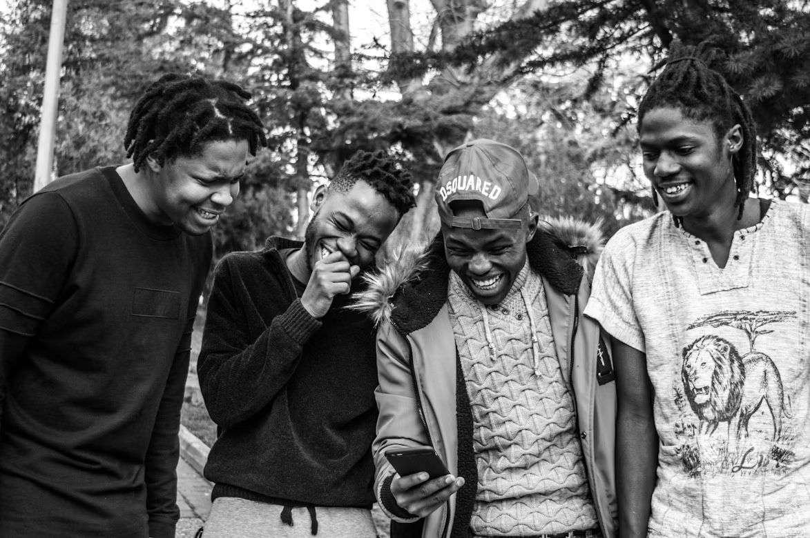 Four young men laughing together outdoors