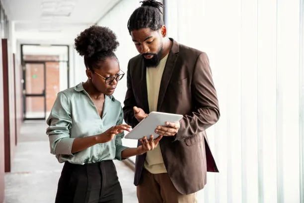 A staff member and resident reviewing a plan together on a tablet in a hallway
